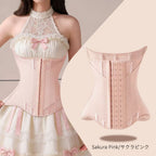 A light pink structured waist trainer corset shown on a model wearing a cream lace halter dress, alongside a clean product view of the back of the corset. The text 'Sakura Pink/サクラピンク' appears at the bottom right.