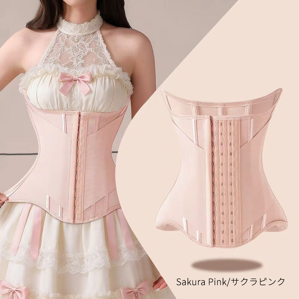 A light pink structured waist trainer corset shown on a model wearing a cream lace halter dress, alongside a clean product view of the back of the corset. The text 'Sakura Pink/サクラピンク' appears at the bottom right.
