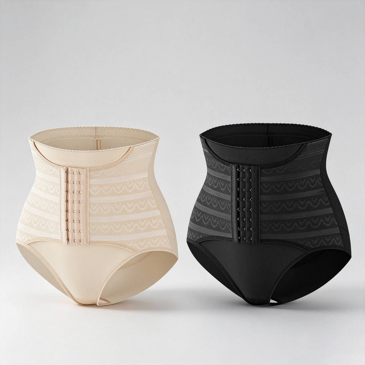 Two high-waisted shaping briefs shown side by side on a light gray studio background: one in light beige with a subtle tonal pattern and center front closure, and one in black with a darker tonal pattern and matching front closure.