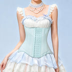 A model wearing a light blue and white corset-style dress top with ruffled straps, lace trim, a pearl choker, and a matching ruffled skirt against a pale blue background.