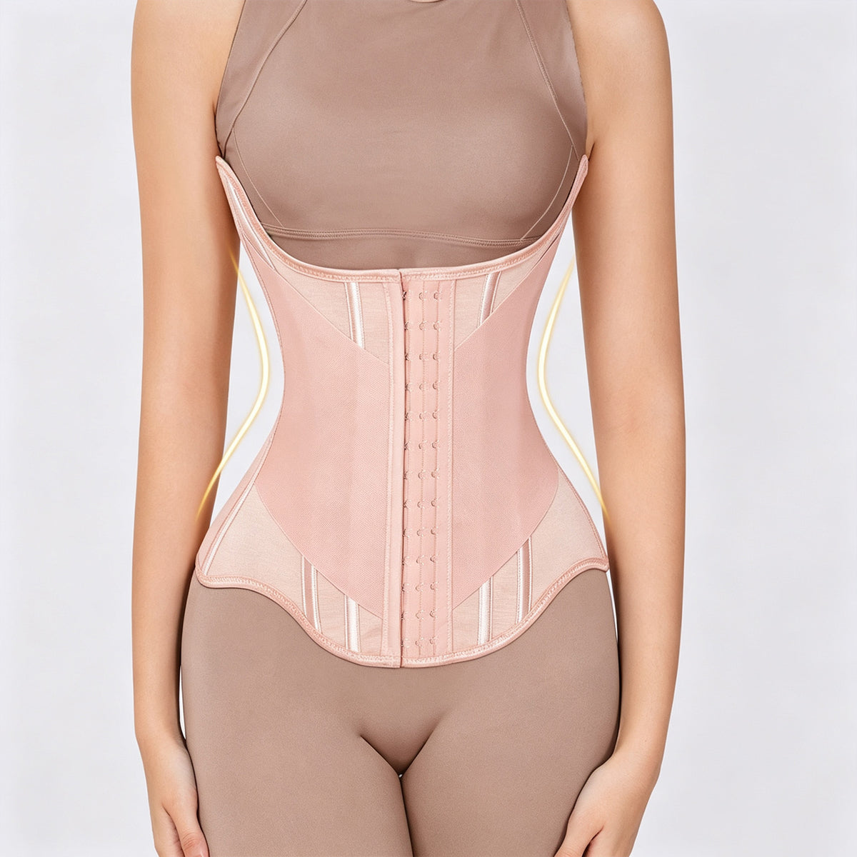 A model wearing a light pink waist trainer corset over matching nude-colored shapewear, shown from the chest down against a light gray background.