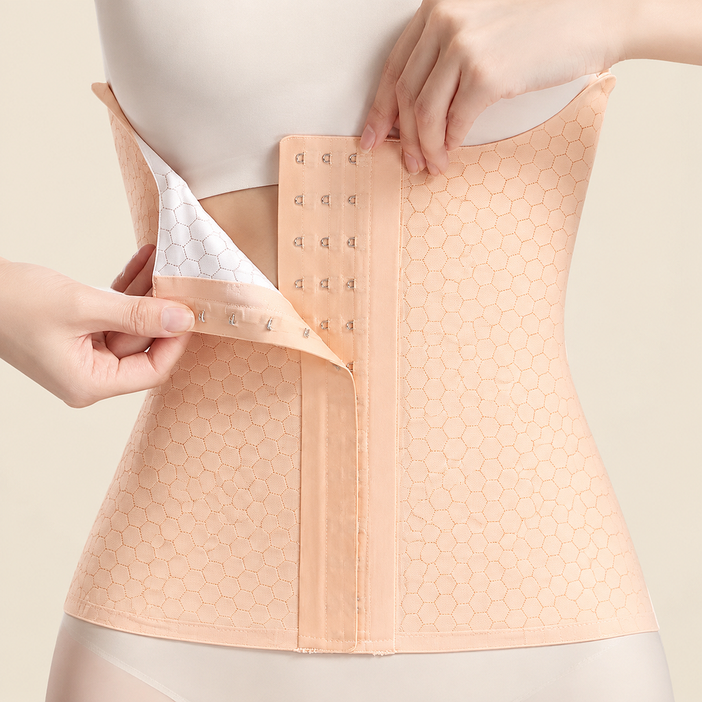 A peach-colored waist trainer corset with a honeycomb pattern, shown on a mannequin torso with hands demonstrating how to fasten the back hook-and-loop closure.