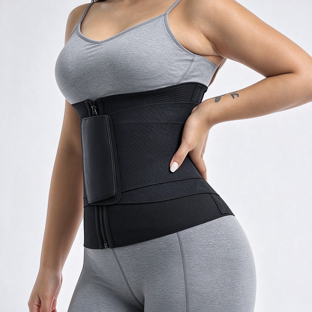 A woman wearing a black waist trainer belt with a zippered pouch on the front, paired with a gray sports bra and leggings, shown against a light gray studio background.