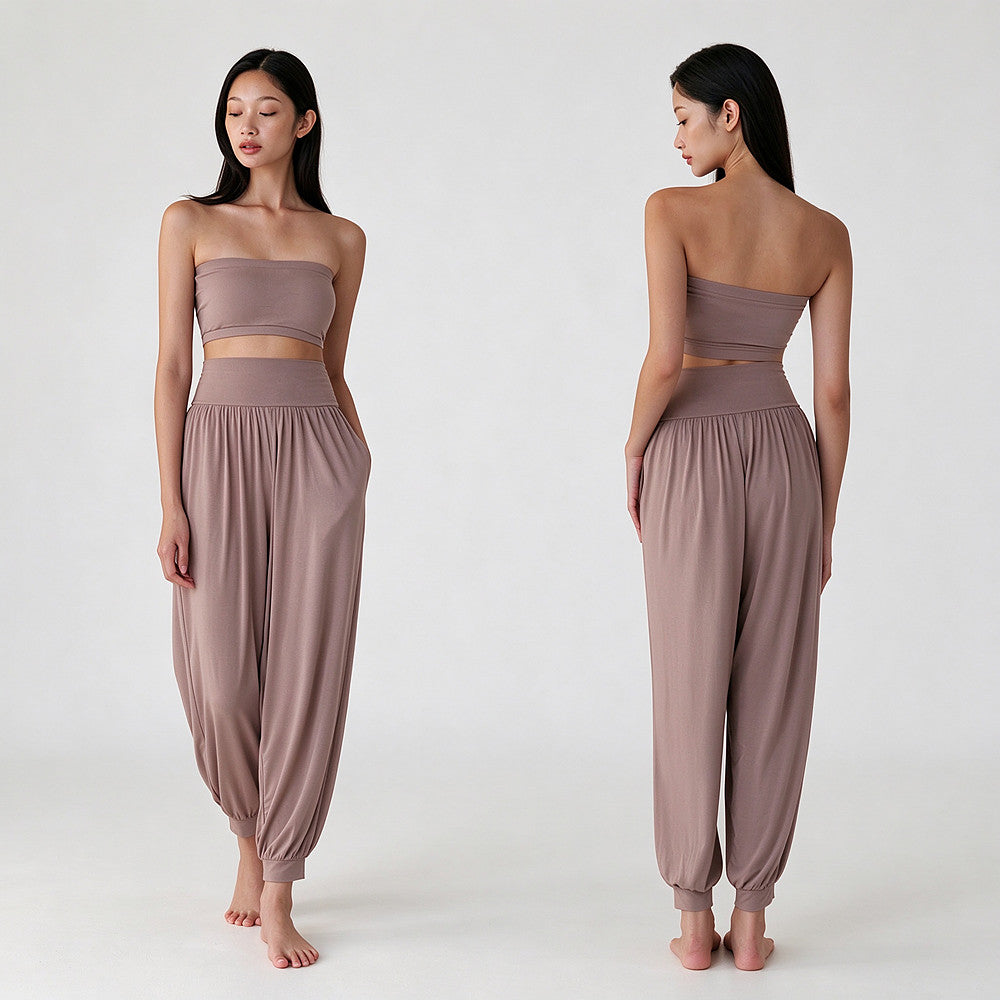 A model is shown from the front and back wearing a two-piece lounge set consisting of a strapless bandeau crop top and matching high-waisted, loose harem pants in a dusty mauve color, set against a plain light gray studio background.