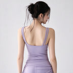 A woman shown from the back wearing a lavender ribbed tank dress with double shoulder straps and a scoop neckline, photographed against a plain light gray studio background.